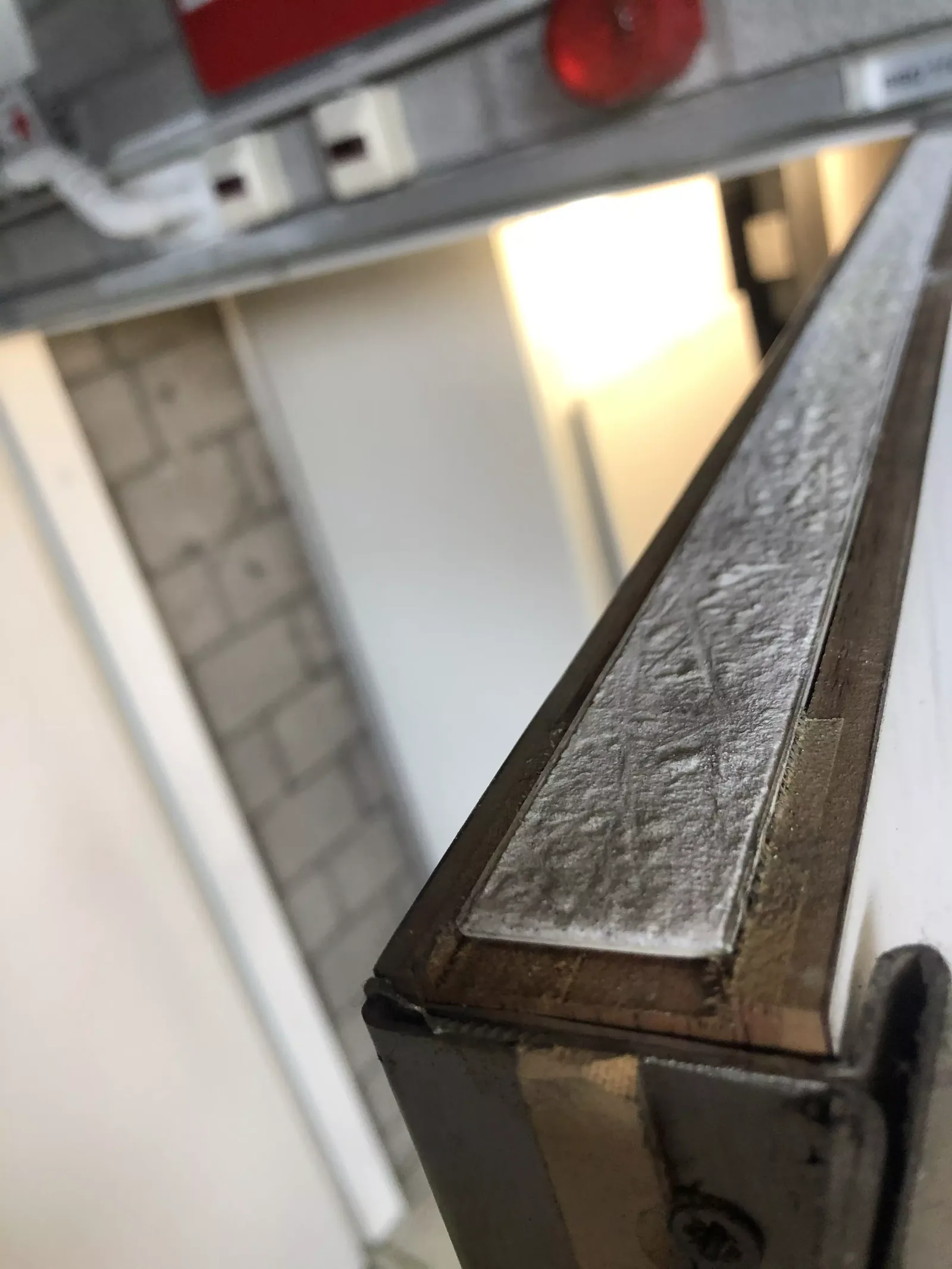 Close-up van een brandwerende afdichting langs een profiel boven een deuropening